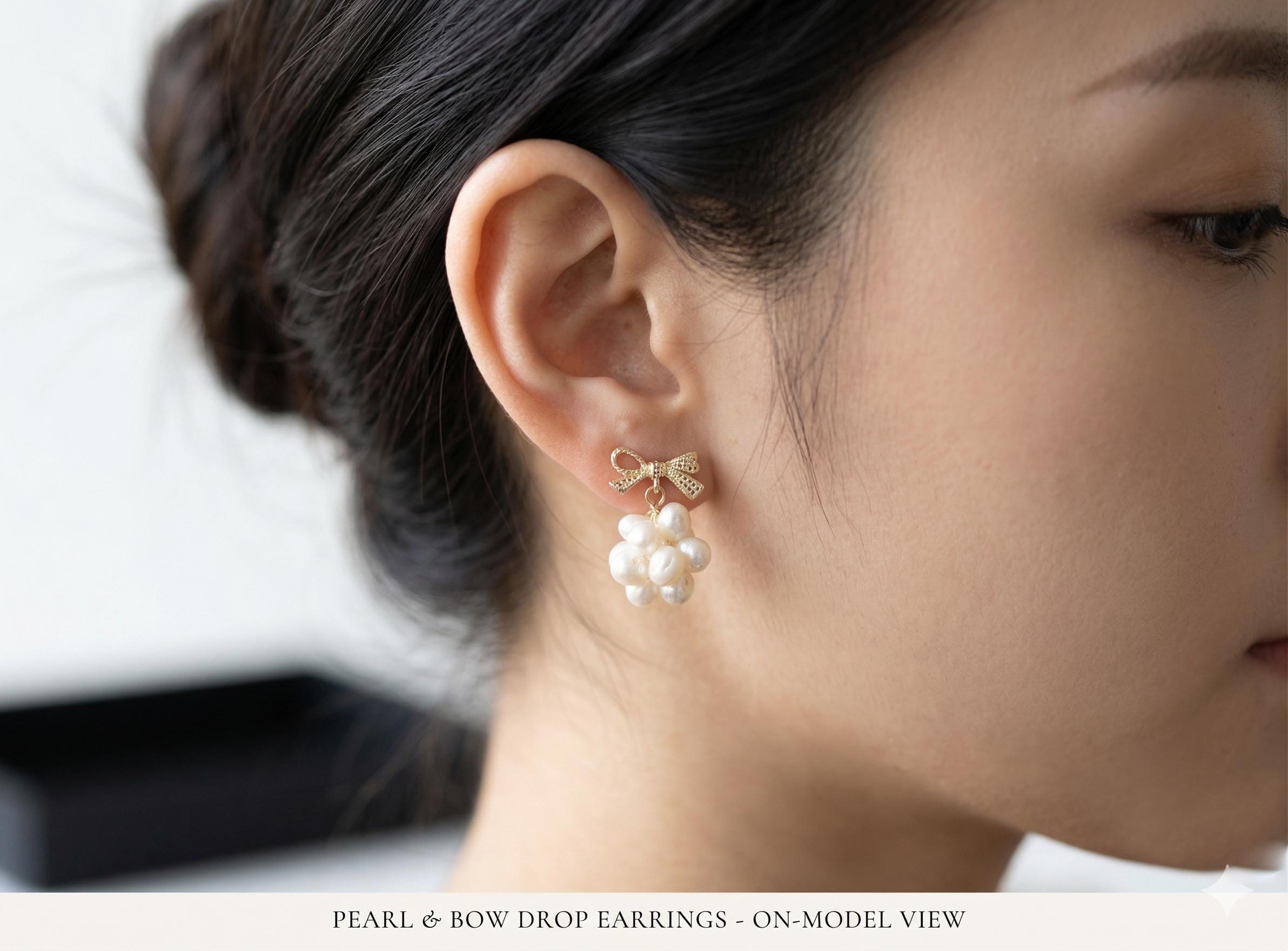 A model wears Caellia 14K gold bowknot earrings featuring a cluster of freshwater pearls.