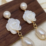 Close up pair of white camellia earrings with round and teardrop pearls