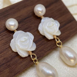 Close up pair of white camellia earrings with round and teardrop pearls
