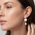 White flower and freshwater pearl dangle earring shown on model for scale