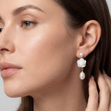 White flower and freshwater pearl dangle earring shown on model for scale