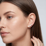 Model wearing gold plated triple pearl leverback earrings for scale