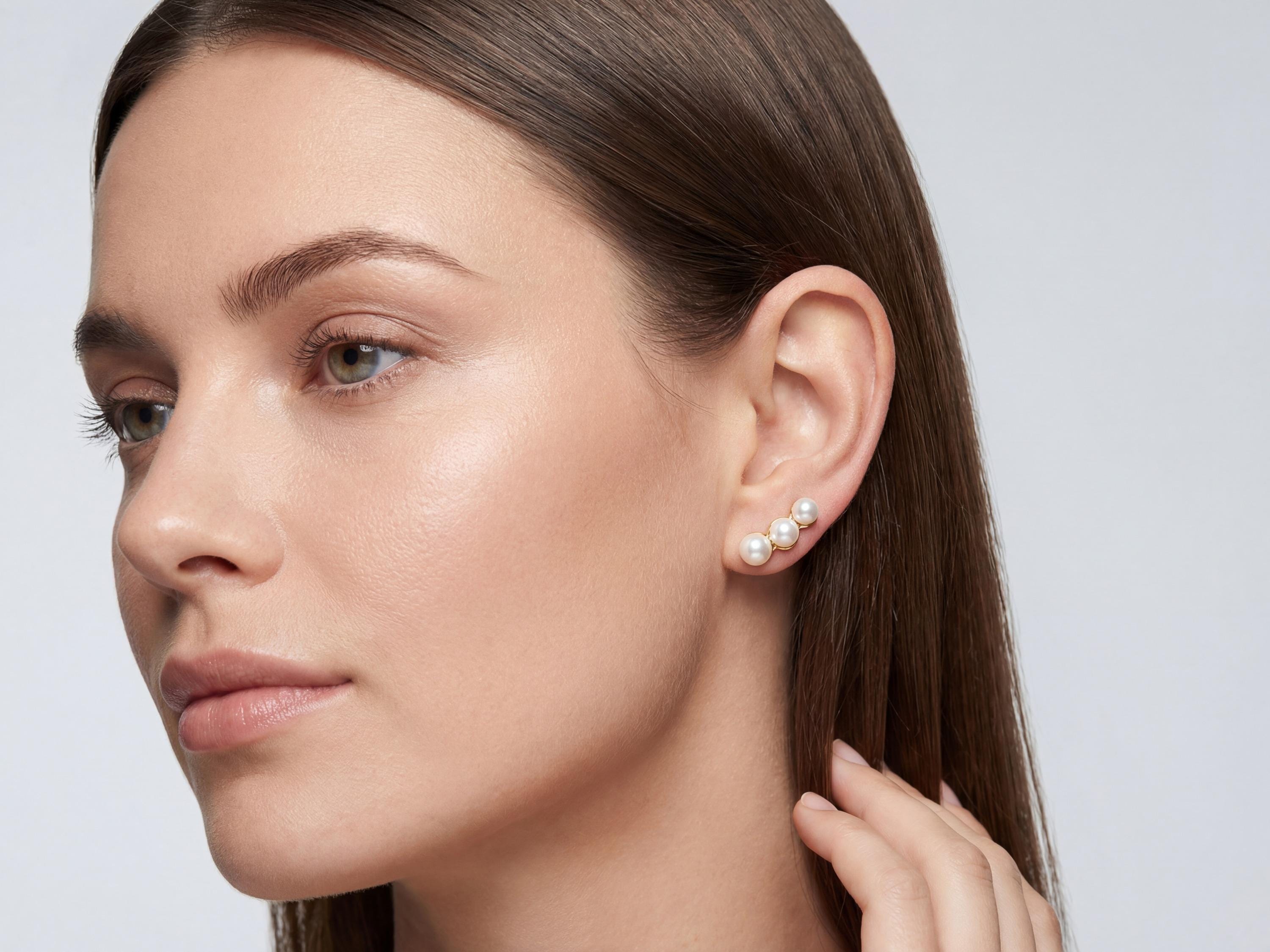 Model wearing gold plated triple pearl leverback earrings for scale