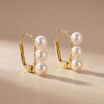 Pair of gold leverback earrings with three round white freshwater pearls on each side