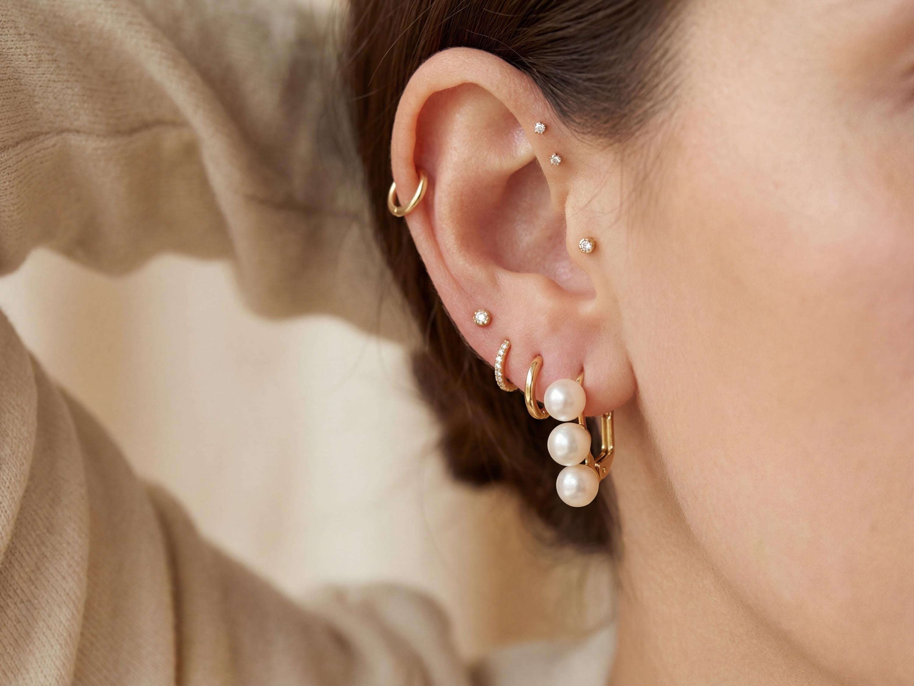 Triple pearl leverback earring styled with a minimalist gold ear stack