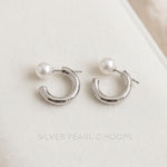 Caellia silver-toned hoop earrings featuring a single freshwater pearl on each.