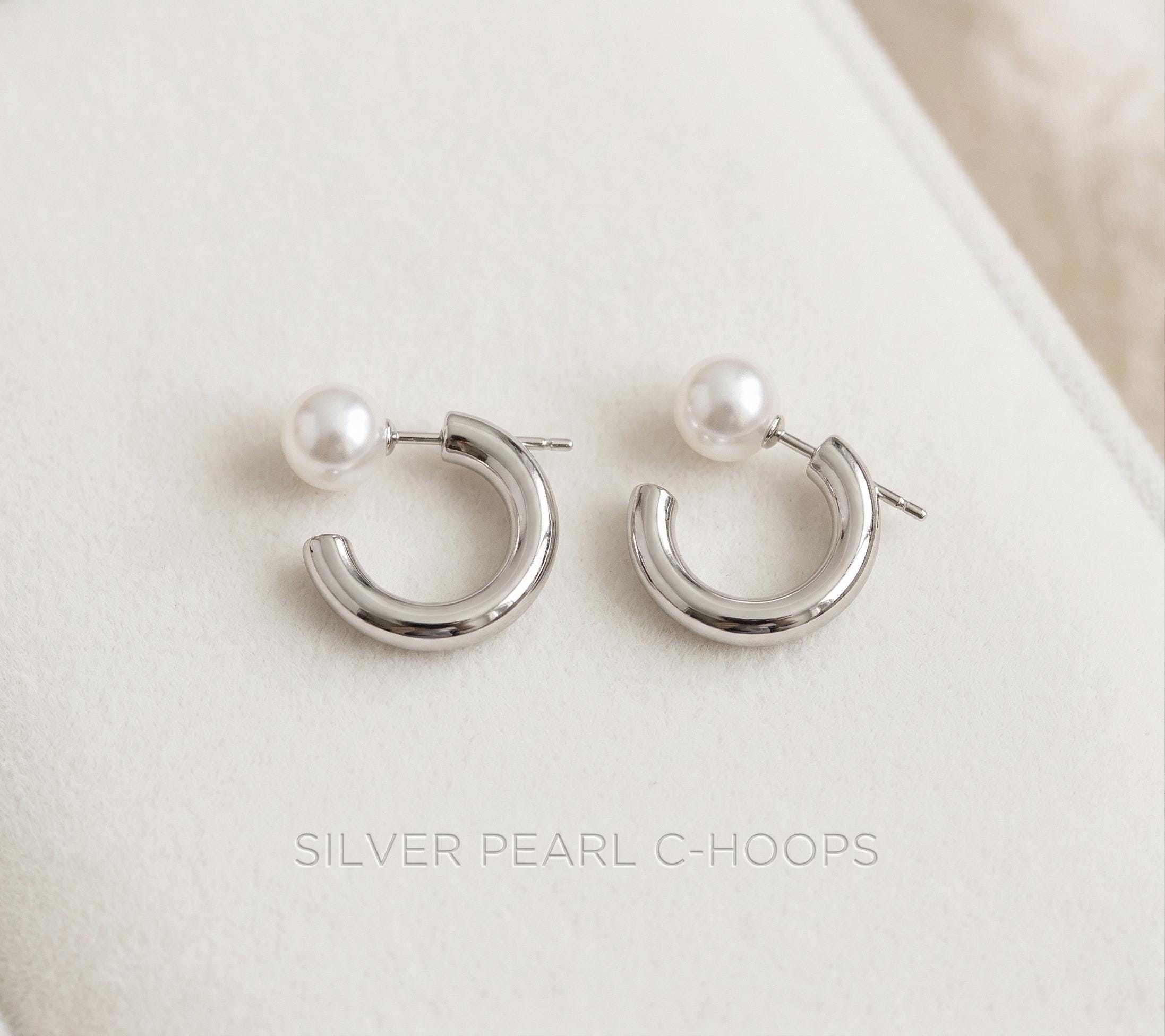 Caellia silver-toned hoop earrings featuring a single freshwater pearl on each.