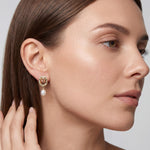 Model wearing a gold rose frame pearl drop stud earring in side profile