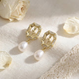 Gold rose pearl drop earrings styled with cream petals and lace