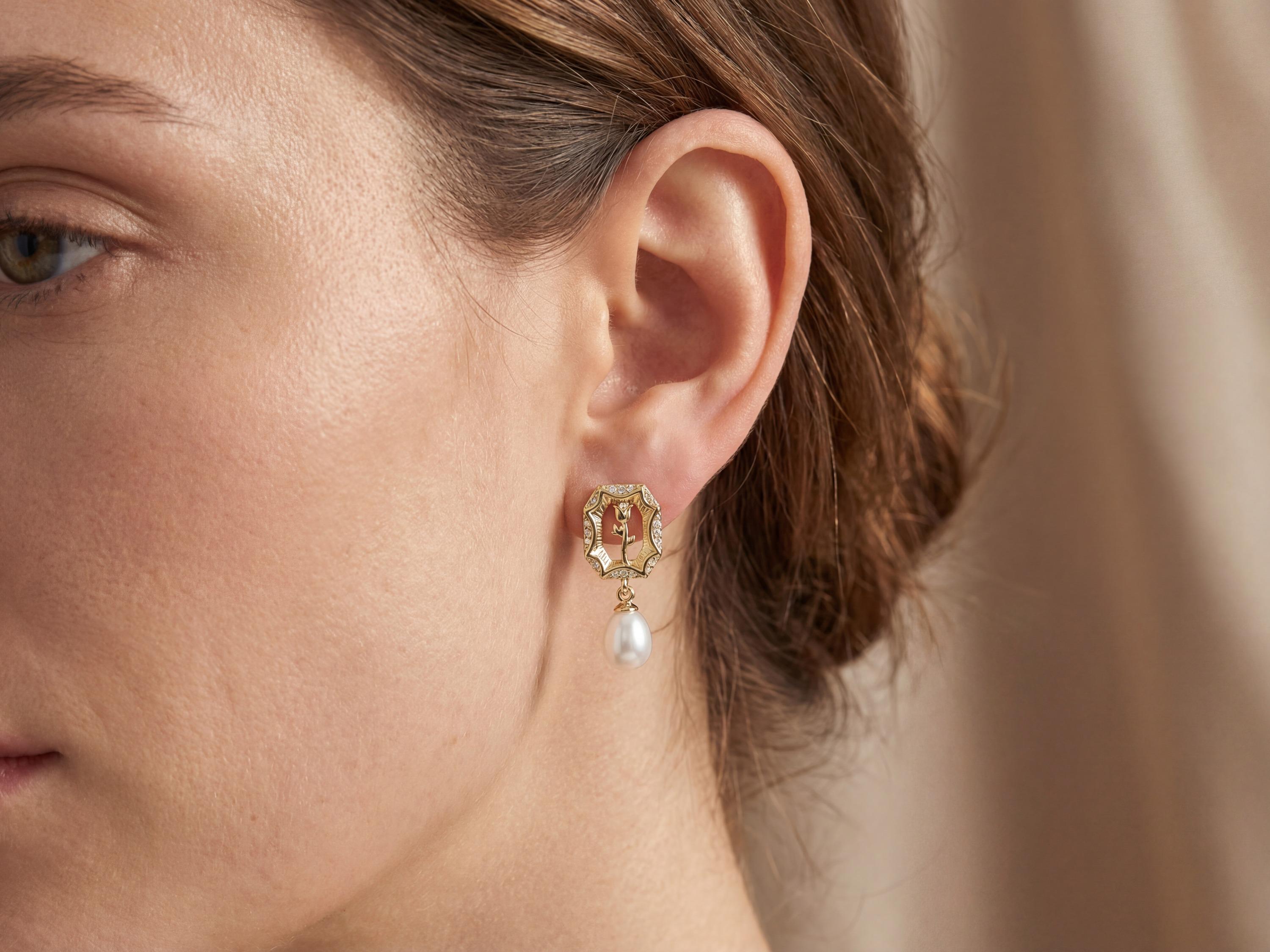 Model wearing a gold rose frame earring with a white freshwater pearl drop