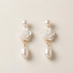 Front view of matching white camellia flower earrings with pearl drops