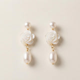 Front view of matching white camellia flower earrings with pearl drops
