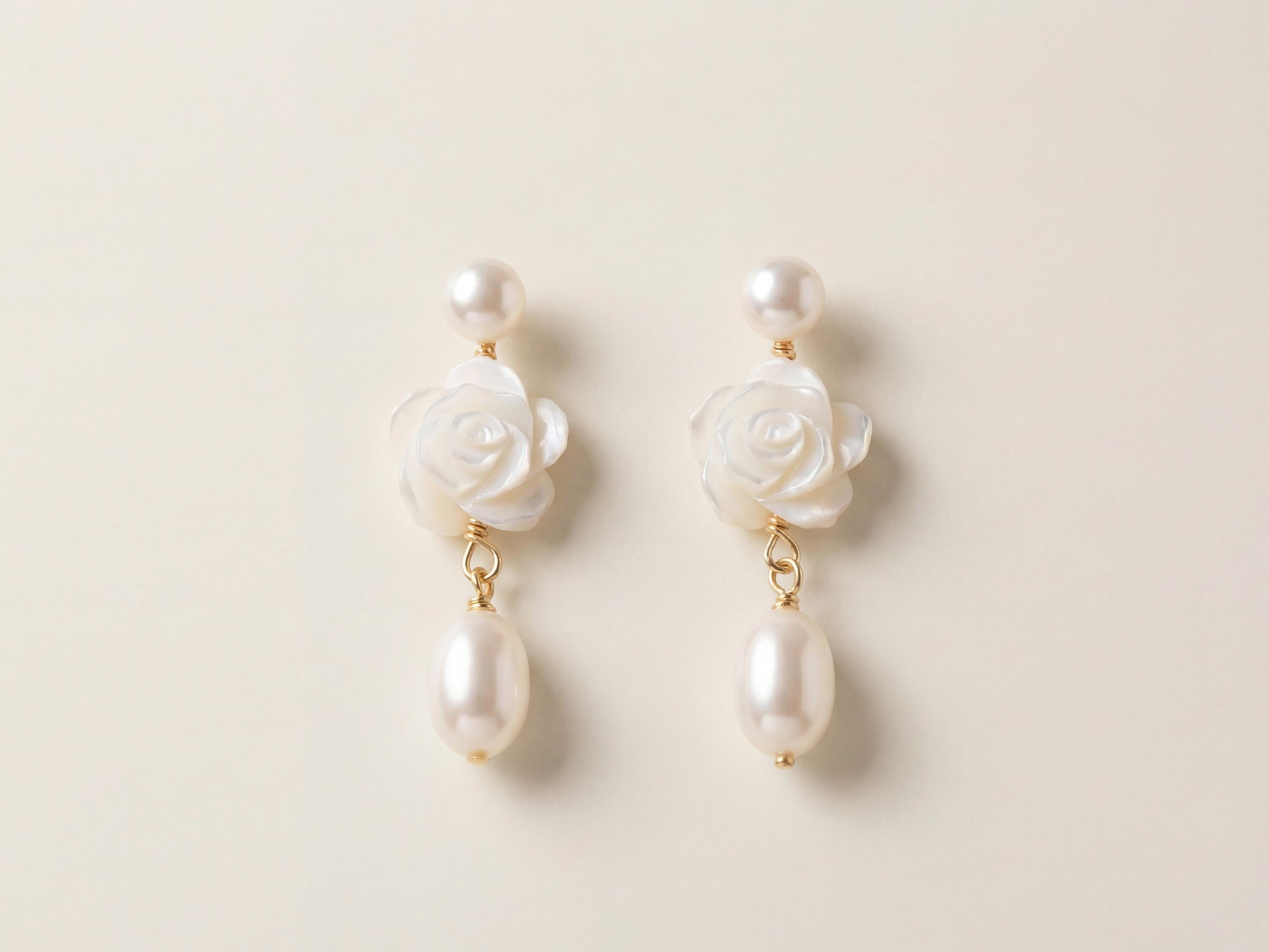 Front view of matching white camellia flower earrings with pearl drops