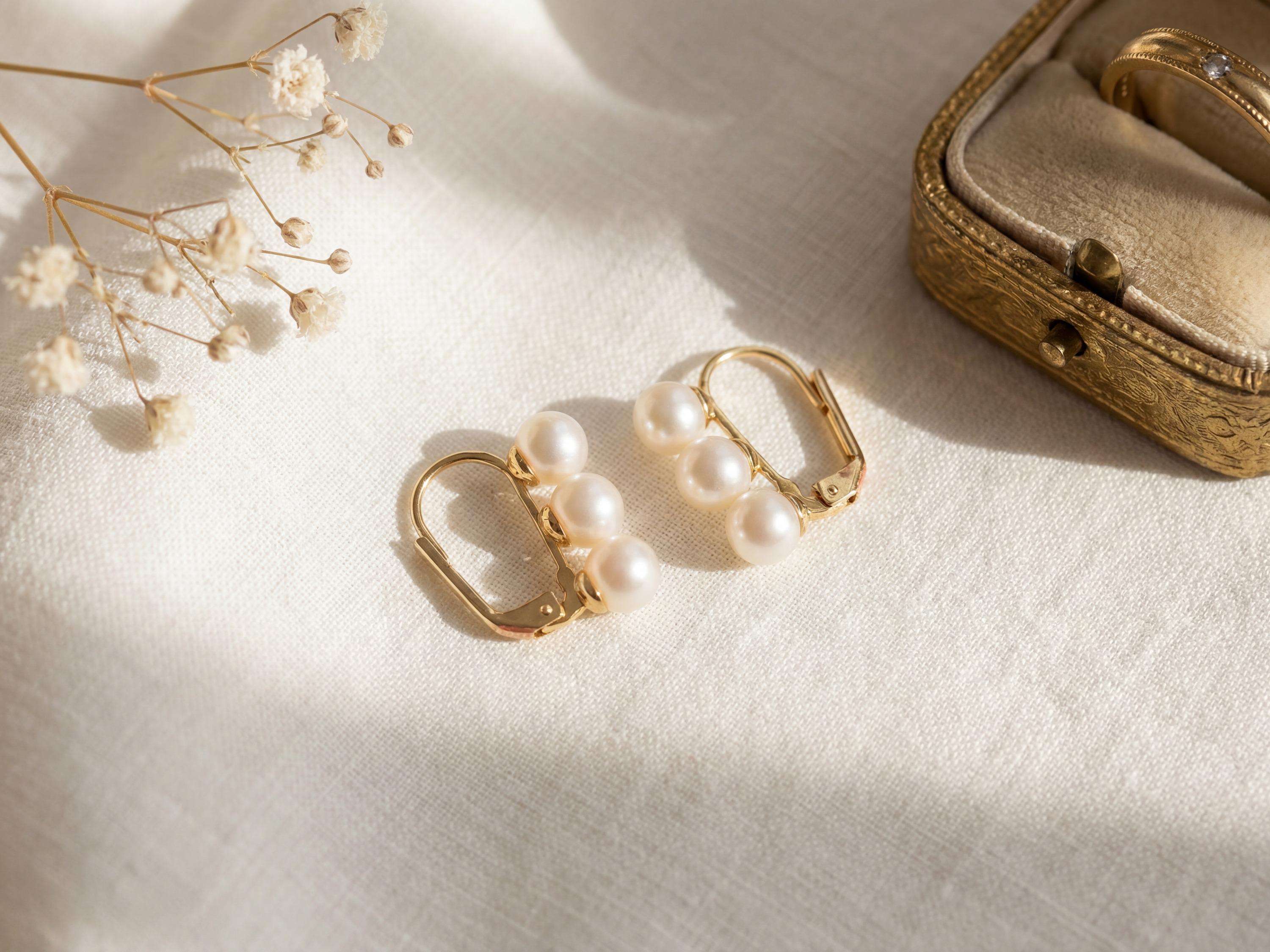 Pair of gold leverback earrings with AAA freshwater pearls in natural light
