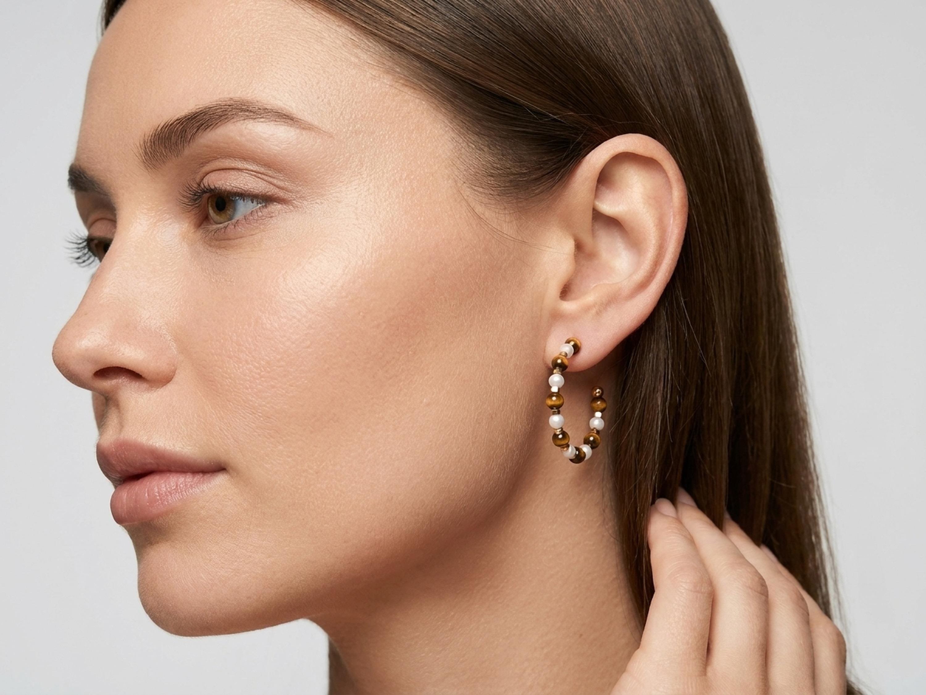 Tiger eye pearl hoop earrings worn by a model, showing the full face and earring scale