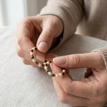 Tiger eye and pearl hoop earrings held in hands to show the beaded design and scale