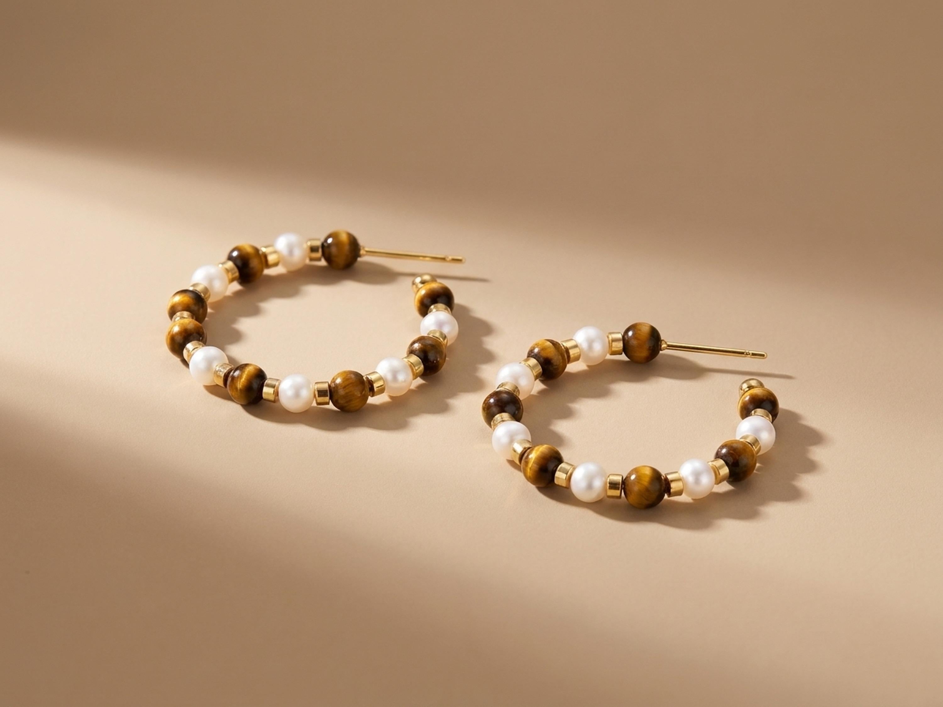 Sculptural close up of tiger eye gemstone and freshwater pearl beaded hoop earrings