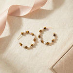 Tiger eye and pearl statement hoop earrings flat lay with blush ribbon and gift box