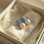 Blue cubic zirconia pearl earrings presented inside a cream gift box