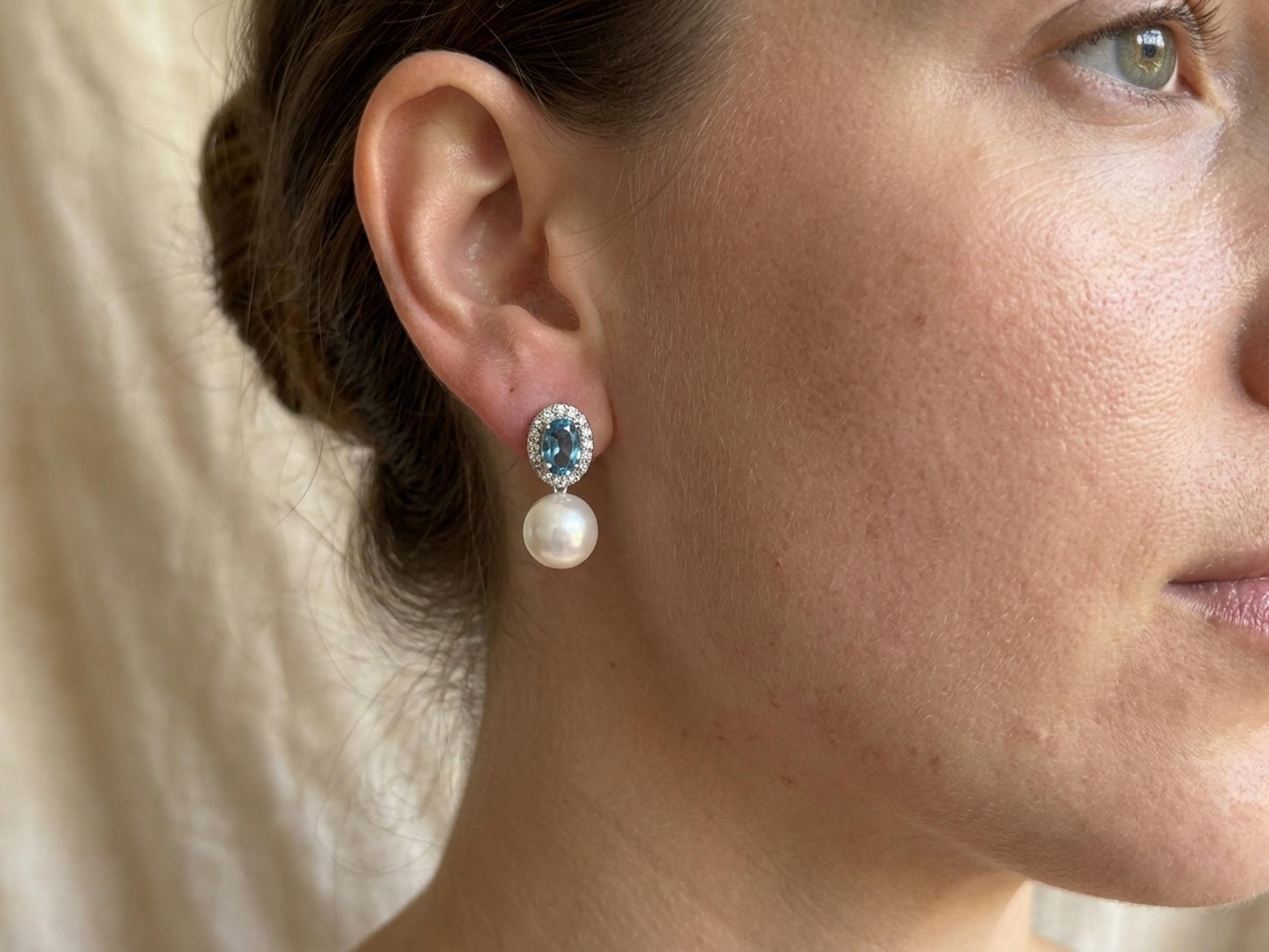 Woman wearing blue cubic zirconia and pearl drop stud earrings in side profile