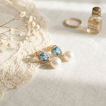 Vintage blue cubic zirconia pearl earrings styled with lace and a perfume bottle