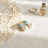 Vintage blue cubic zirconia pearl earrings styled with lace and a perfume bottle