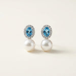 Front view of matching blue cubic zirconia and white pearl drop stud earrings