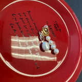 Mismatched pearl earrings with one large pearl and a cluster of four smaller pearls.