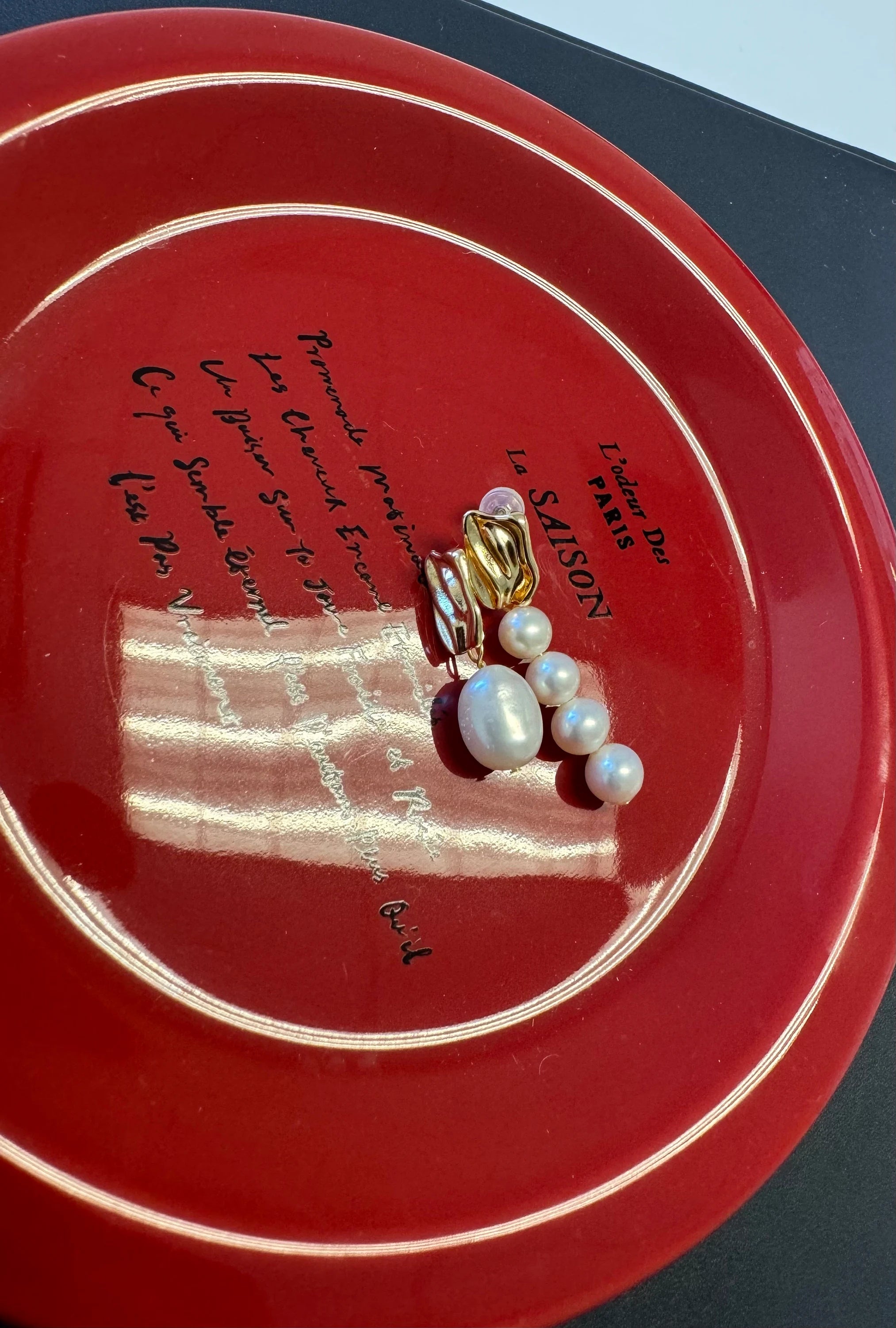 Mismatched pearl earrings with one large pearl and a cluster of four smaller pearls.