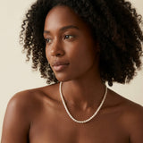 A model wears the Caellia 14K gold tiny freshwater pearl necklace.