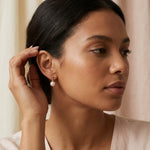 A model wears Caellia 14K gold plated sterling silver freshwater pearl dangle earrings.