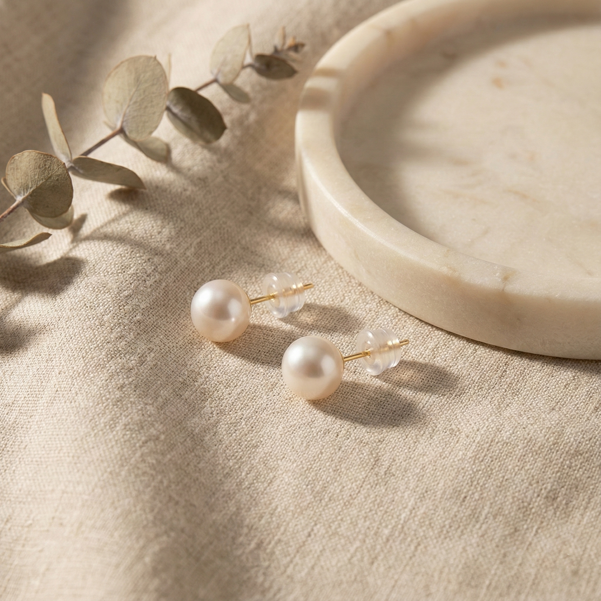 Caellia freshwater pearl stud earrings in 18K gold with clear backs.