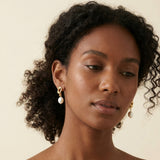 A model wears Caellia 14K gold twist knot earrings featuring lustrous freshwater pearls.