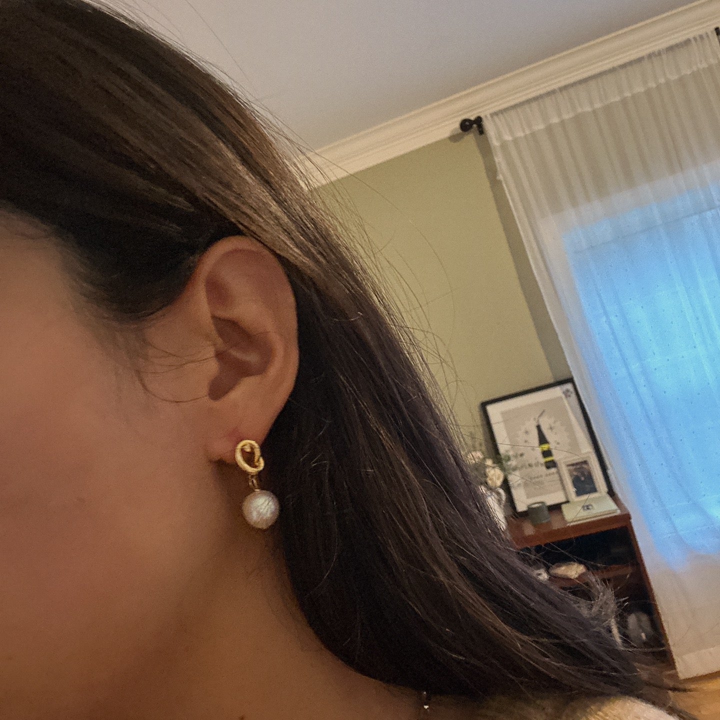 Twist drop pearl earrings with a gold knot design and white pearls.