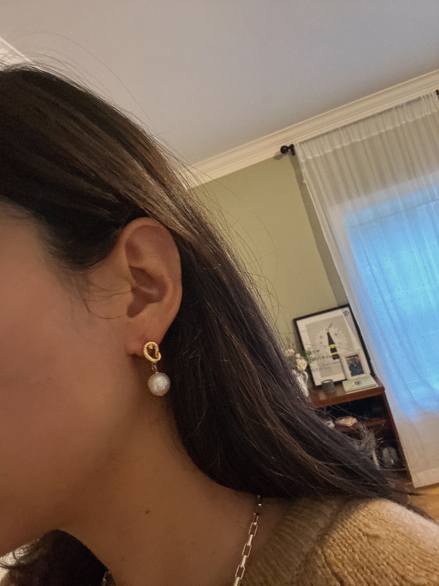 Twist drop pearl earrings with a gold knot design and white pearls.