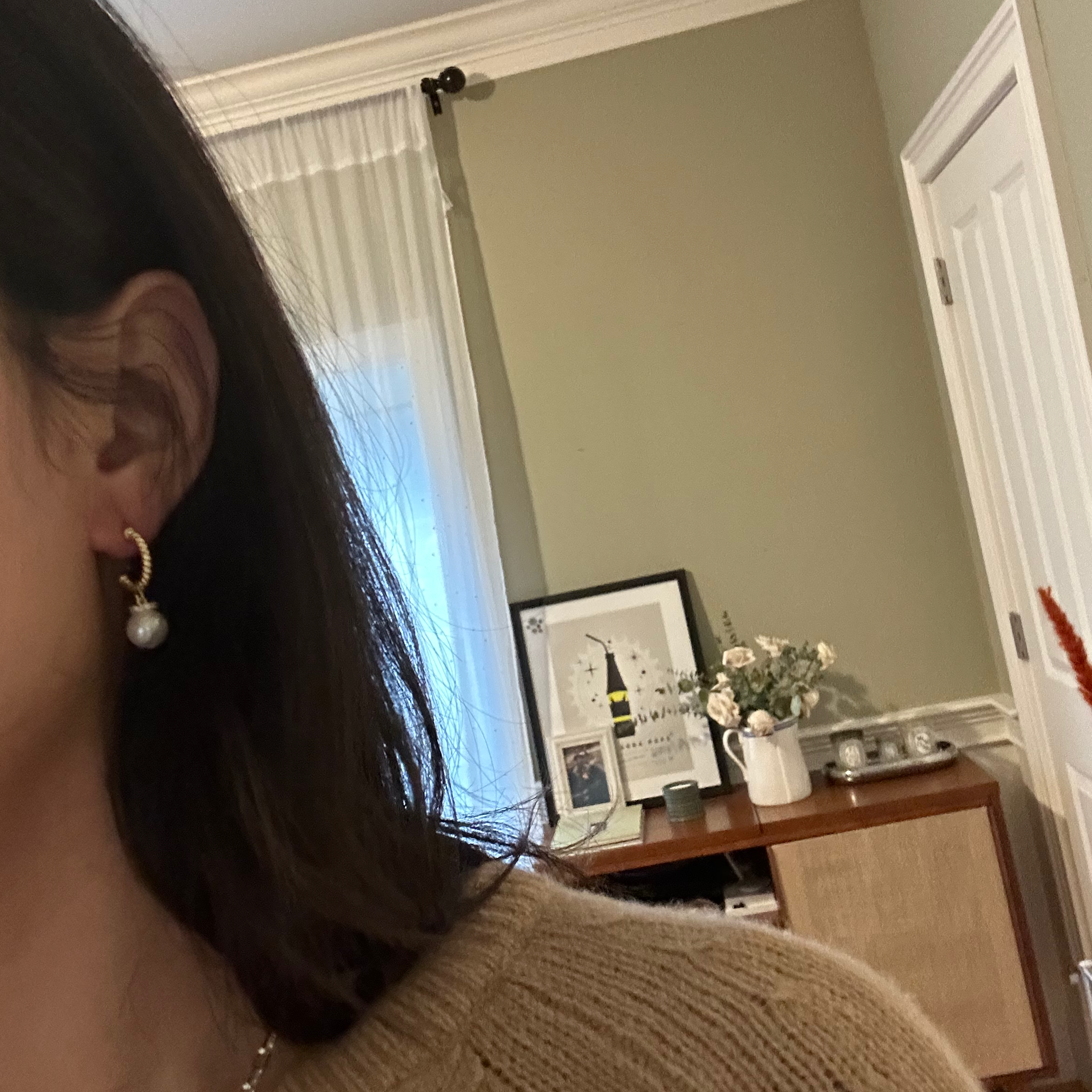 Half hoop pearl earrings with a gold-plated setting.