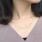 Dainty pearl necklace with a gold-plated chain worn by a person.