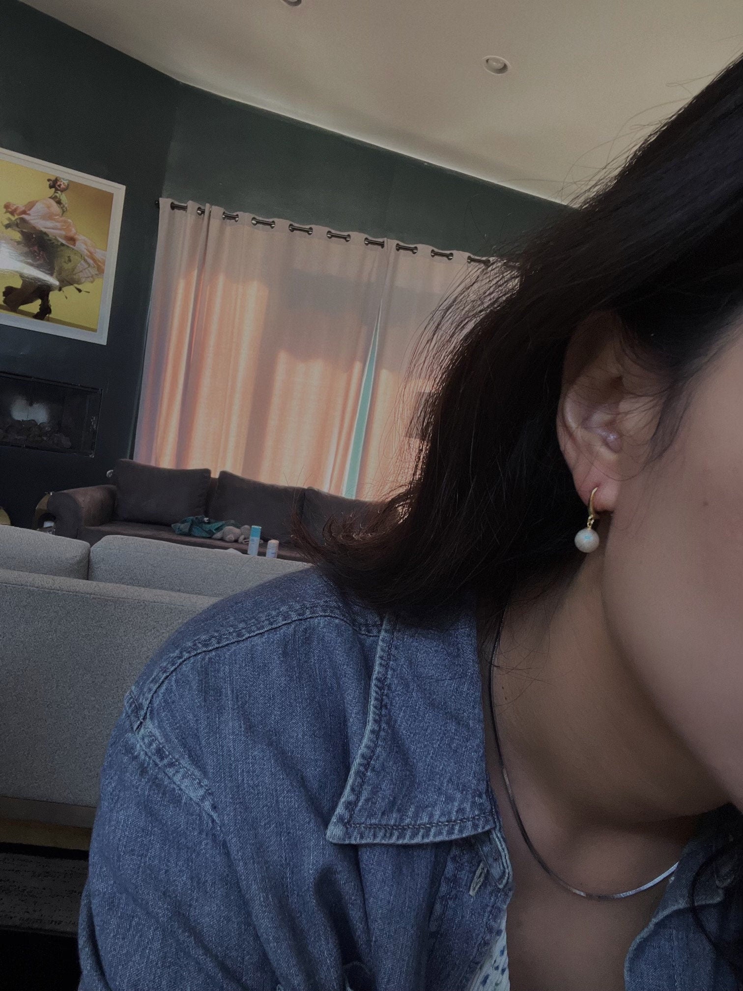 Pearl hoop earrings featuring a single white pearl on a gold-toned hoop.