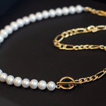 A white freshwater pearl necklace with a gold-plated chain and toggle clasp.