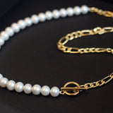 A white freshwater pearl necklace with a gold-plated chain and toggle clasp.