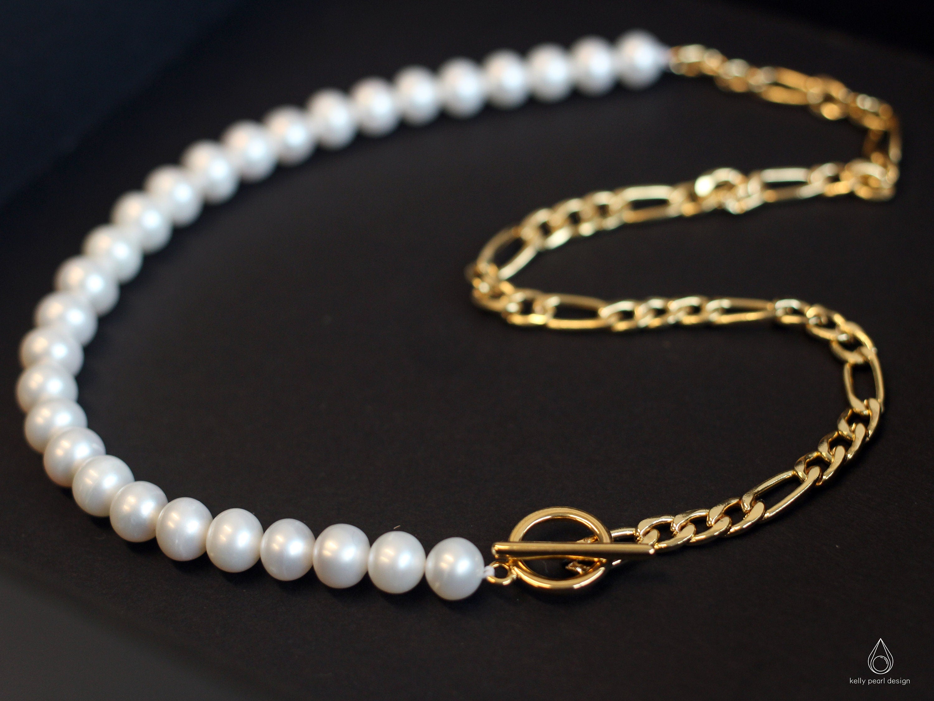 A white freshwater pearl necklace with a gold-plated chain and toggle clasp.