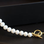 A freshwater pearl necklace with a gold-plated chain and toggle clasp.