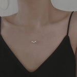 Three pearl bead necklace with a gold-plated chain on a person's neck.