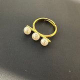 Gold-toned ring with three freshwater pearls arranged in a line.
