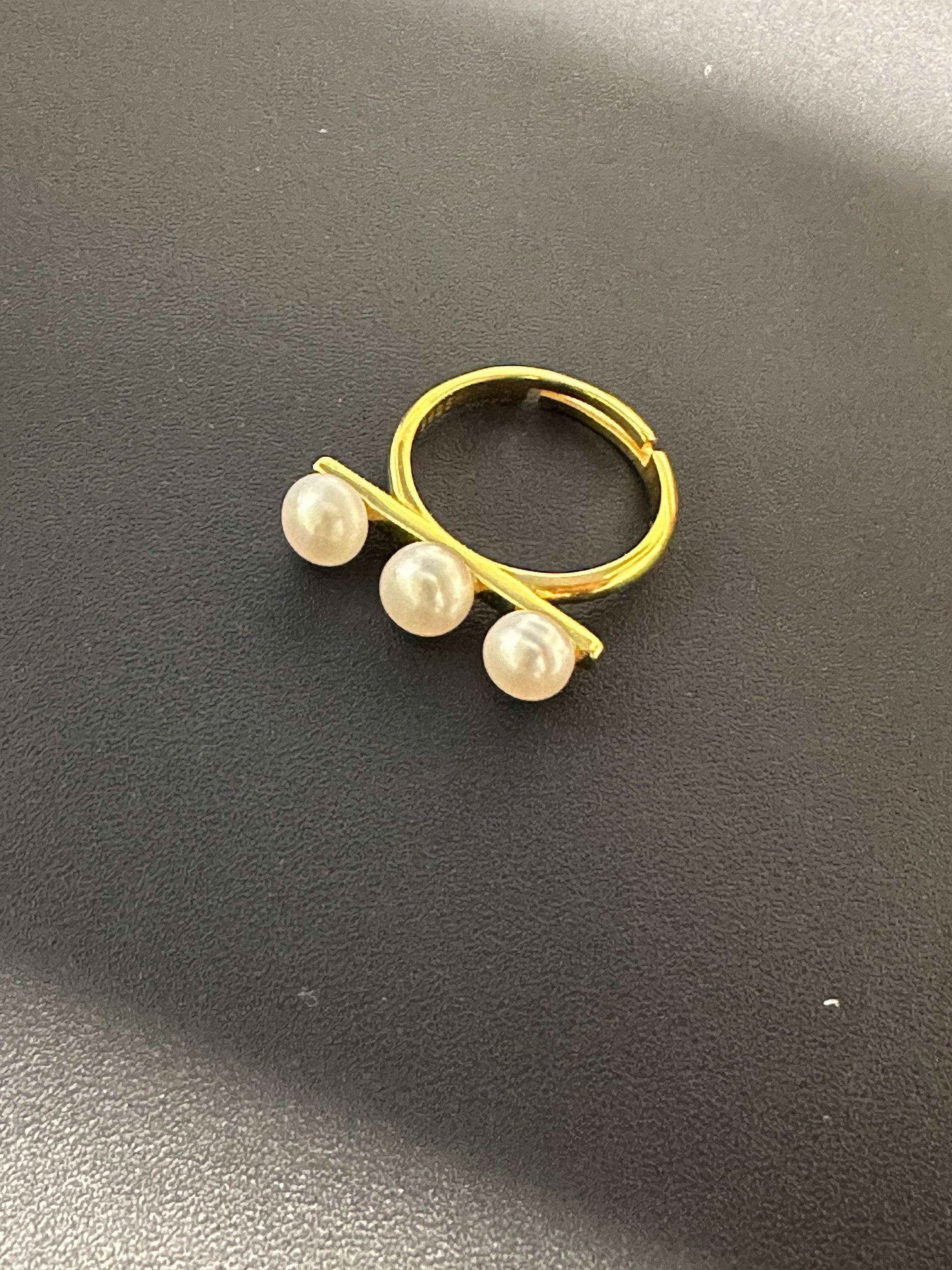 Gold-toned ring with three freshwater pearls arranged in a line.
